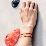 Cord bracelet with gold suitcase and heart 